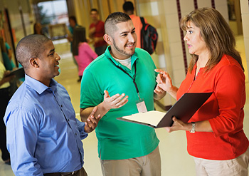 3 teachers talking in a school hallway