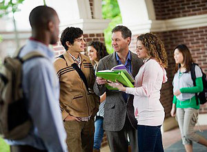 Students talk to teacher on campus